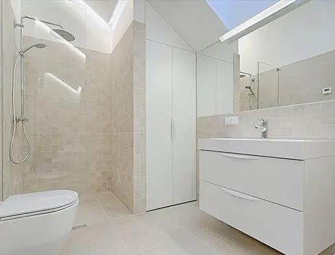 A bathroom with white tile and walls.