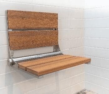 A wooden bench seat in the corner of a bathroom.